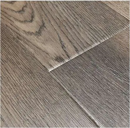 Close detail of a wood-look flooring surface, grain and pressed bevel.